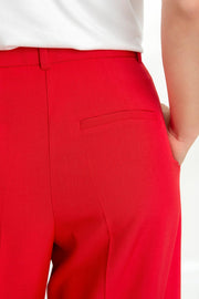 Pantalón de fit wide leg, cintura alta con pretina y trabillas, pinzas frontales con raya frontal, bolsillos delanteros, vivo decorativo posterior, cierre frontal con broche y cremallera ocultos.