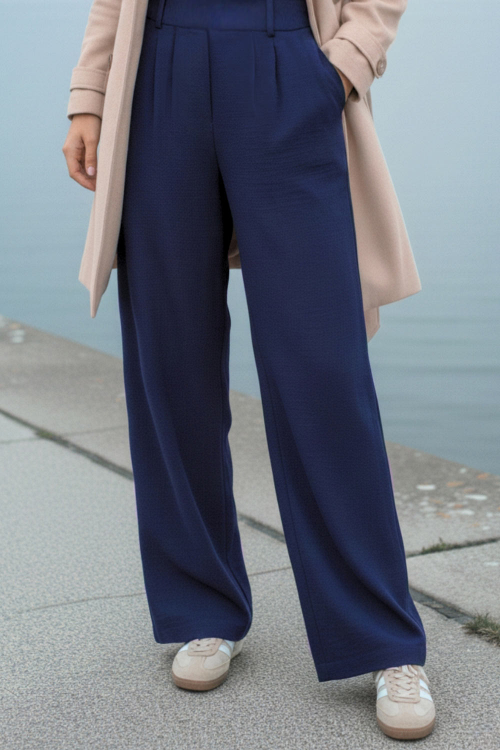 Pantalón fluido de fit wide leg, cintura alta con pretina elástica posterior, trabillas, pinzas frontales y bolsillos delanteros.