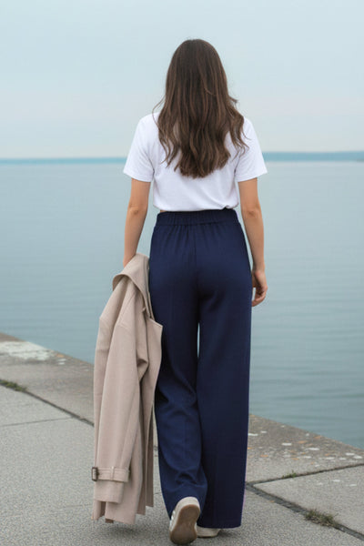 Pantalón fluido de fit wide leg, cintura alta con pretina elástica posterior, trabillas, pinzas frontales y bolsillos delanteros.