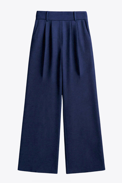 Pantalón fluido de fit wide leg, cintura alta con pretina elástica posterior, trabillas, pinzas frontales y bolsillos delanteros.