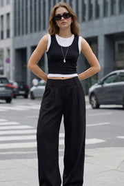 Pantalón fluido de fit wide leg, cintura alta con pretina elástica posterior, trabillas, pinzas frontales y bolsillos delanteros.