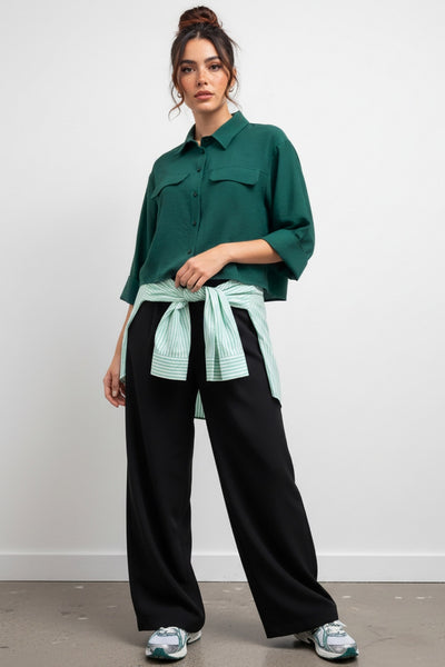 Pantalón fluido de fit wide leg, cintura alta con pretina elástica posterior, trabillas, pinzas frontales y bolsillos delanteros.