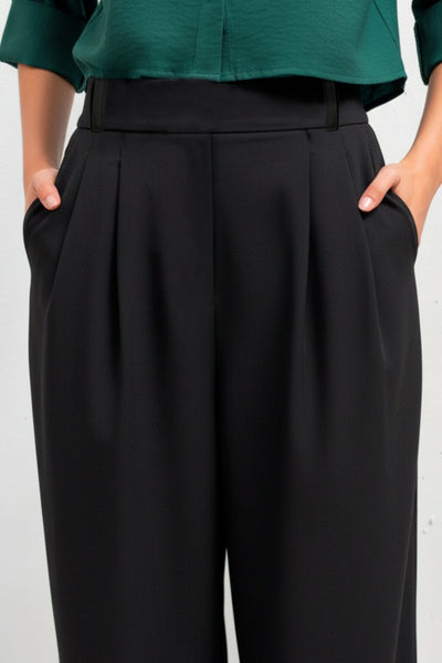 Pantalón fluido de fit wide leg, cintura alta con pretina elástica posterior, trabillas, pinzas frontales y bolsillos delanteros.