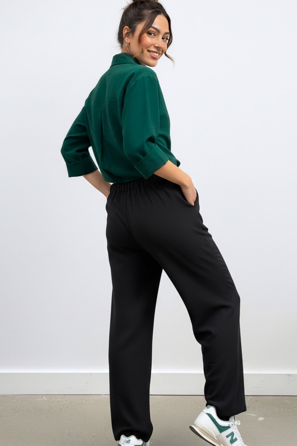 Pantalón fluido de fit wide leg, cintura alta con pretina elástica posterior, trabillas, pinzas frontales y bolsillos delanteros.