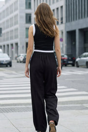Pantalón fluido de fit wide leg, cintura alta con pretina elástica posterior, trabillas, pinzas frontales y bolsillos delanteros.