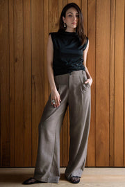 Pantalón fluido de cintura alta con trabillas, fit wide leg, pinzas frontales, bolsillos delanteros y vivos posteriores. Cierre frontal con botón y cremallera oculta.