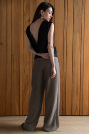 Pantalón fluido de cintura alta con trabillas, fit wide leg, pinzas frontales, bolsillos delanteros y vivos posteriores. Cierre frontal con botón y cremallera oculta.