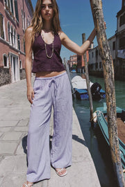 Pantalón fluido de fit palazzo, cintura media con pretina elástica y jareta frontal ajustable.