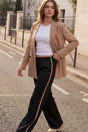 Pantalón fluido de fit recto, cintura media con pretina elástica, bolsillos delanteros, costura frontal y raya lateral decorativa en contraste.