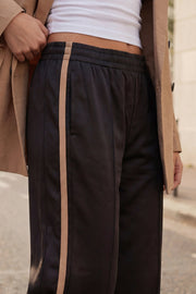 Pantalón fluido de fit recto, cintura media con pretina elástica, bolsillos delanteros, costura frontal y raya lateral decorativa en contraste.