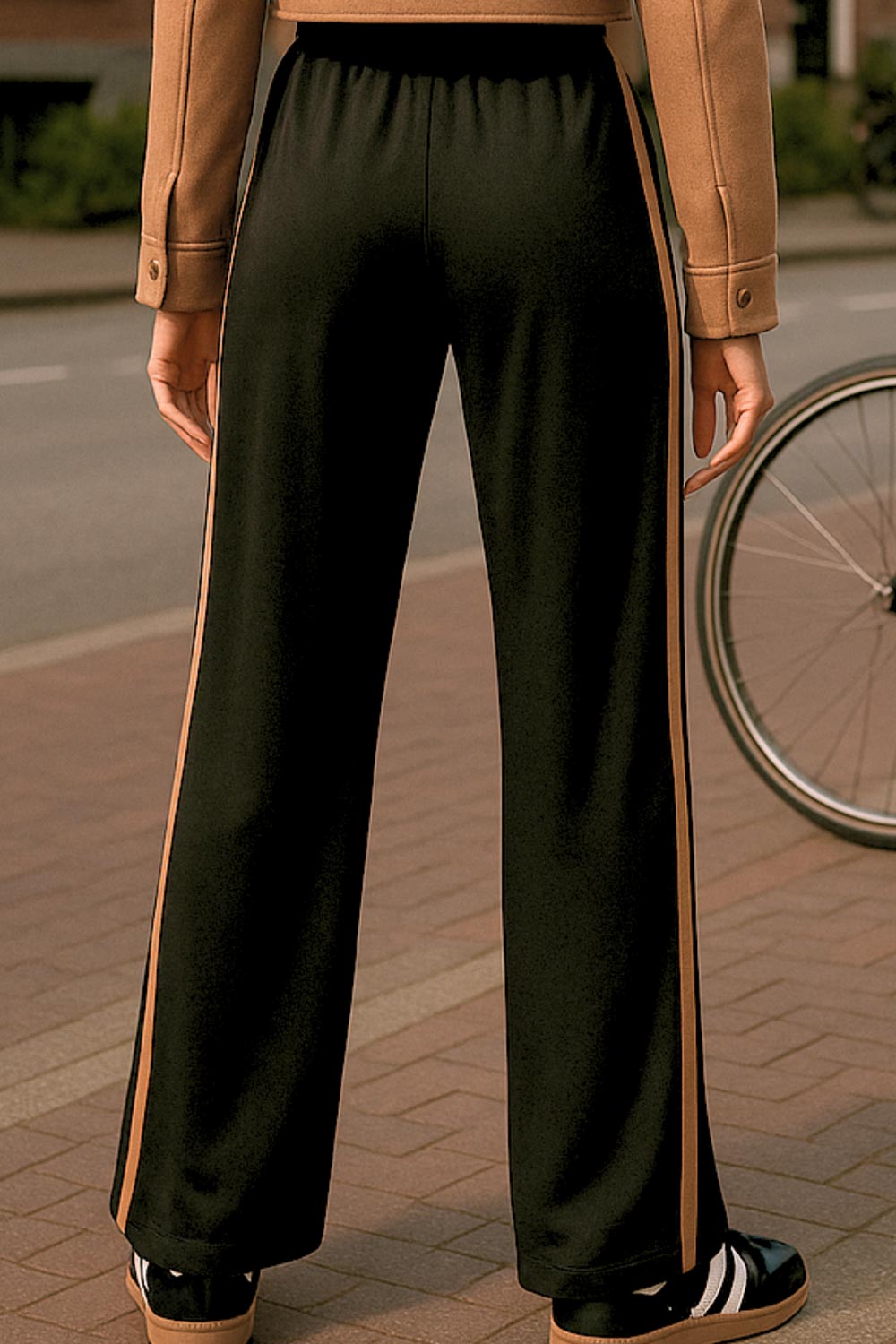 Pantalón fluido de fit recto, cintura media con pretina elástica, bolsillos delanteros, costura frontal y raya lateral decorativa en contraste.