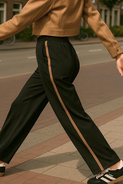 Pantalón fluido de fit recto, cintura media con pretina elástica, bolsillos delanteros, costura frontal y raya lateral decorativa en contraste.