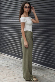 Pantalón fluido de fit wide leg, pinzas frontales, bolsillos delanteros y cintura alta con pretina elástica posterior.