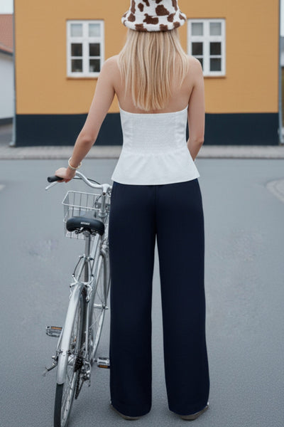 Pantalón fluido de fit wide leg, pinzas frontales, bolsillos delanteros y cintura alta con pretina elástica posterior.