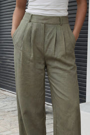 Pantalón fluido de fit wide leg, pinzas frontales, bolsillos delanteros y cintura alta con pretina elástica posterior.
