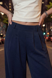 Pantalón fluido de fit wide leg, pinzas frontales, bolsillos delanteros y cintura alta con pretina elástica posterior.