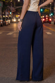 Pantalón fluido de fit wide leg, pinzas frontales, bolsillos delanteros y cintura alta con pretina elástica posterior.