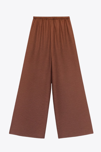 Pantalón fluido de fit wide leg, cintura alta con pretina elástica posterior, pinzas frontales, bolsillos delanteros y jareta frontal ajustable.