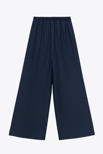 Pantalón fluido de fit wide leg, cintura alta con pretina elástica posterior, pinzas frontales, bolsillos delanteros y jareta frontal ajustable.