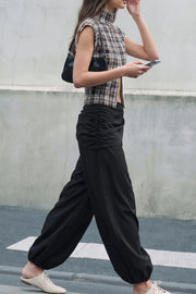 Pantalón de fit balloon, cintura media elástica, bolsillos delanteros, detalle de pareo decorativo con plisados y nudo lateral.