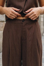 Pantalón de fit balloon, estampado rayas, cintura alta con pretina elástica posterior, bolsillos delanteros, pinzas frontales y bajo globo con rib elástico. Cierre frontal con botón y cremallera oculta.