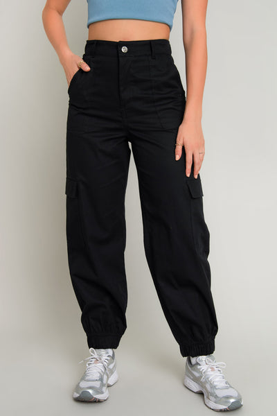 Pantalón jogger cargo de fit recto, cintura alta con pretina elástica posterior y trabillas, bolsillos delanteros de parche y laterales parche con cartera. Cierre frontal con botón en contraste y cremallera oculta. Detalle de rib elástico en bajo.