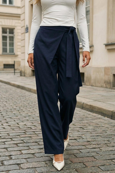 Pantalón de fit wide leg, pinzas frontales, cintura alta y cruce frontal con lazo amarrable lateral. Detalle de vivo posterior.