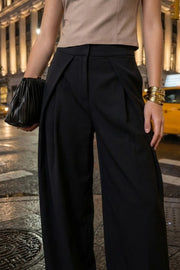 Pantalón wide leg de cintura alta con pretina, pinzas con detalle decorativo frontal, bolsillos delanteros, cierre frontal con broche y cremallera ocultos.