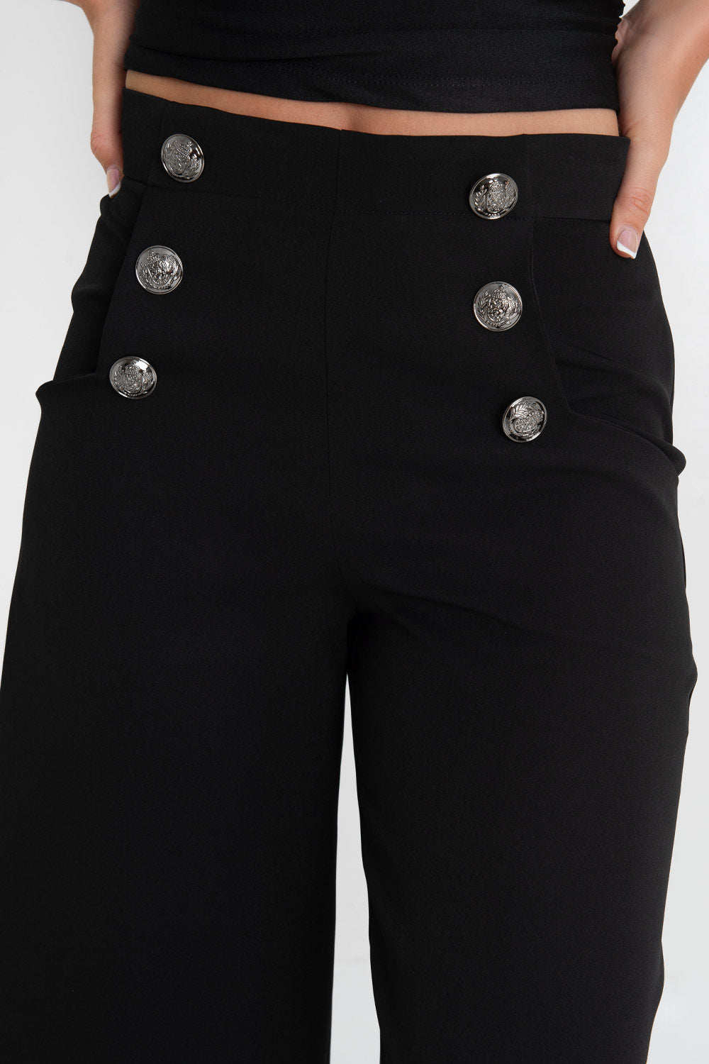 Pantalón marinero cropped flare fit, raya frontal, cintura alta con pretina y bolsillos delanteros con botones decorativos en contraste. Cierre lateral con cremallera oculta.