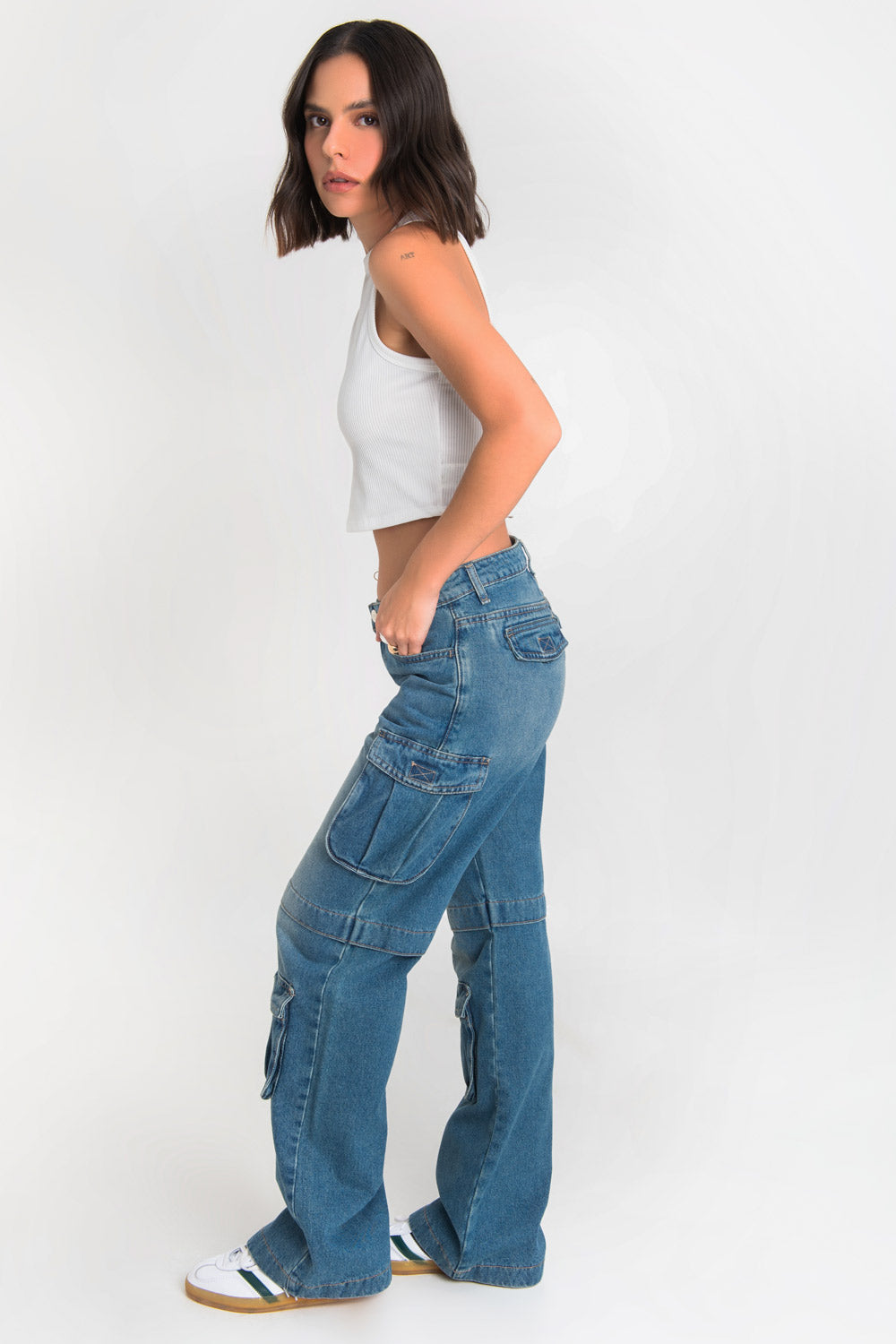 Pantalón multipocket cargo de denim, cintura alta con pretina y trabillas, de fit wide leg, bolsillos delanteros, laterales cargo y posteriores decorativos con cartera. Detalle cortes con costura en rodilla, cierre frontal con botón y cremallera oculta.