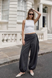 Pantalón fluido de fit palazzo, estampado rayas, cintura media con pretina elástica, plisados en costado y detalle de pareo decorativo con nudo lateral.