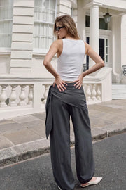 Pantalón fluido de fit palazzo, estampado rayas, cintura media con pretina elástica, plisados en costado y detalle de pareo decorativo con nudo lateral.