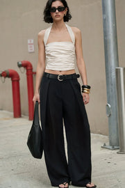 Pantalón wide leg de cintura alta con pretina y trabillas, pinzas con detalle decorativo frontal, bolsillos delanteros y vivos decorativos posteriores. Cierre frontal con broche y cremallera ocultos.