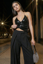 Pantalón wide leg de cintura alta con pretina, pinzas con detalle decorativo frontal, bolsillos delanteros, cierre frontal con broche y cremallera ocultos.