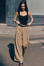 Pantalón wide leg de cintura alta con pretina y trabillas, pinzas frontales, bolsillos delanteros y vivos decorativos posteriores. Cierre frontal con broche y cremallera ocultos. Detalle de cinturón en contraste con hebilla.