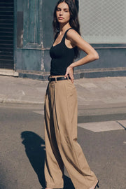 Pantalón wide leg de cintura alta con pretina y trabillas, pinzas frontales, bolsillos delanteros y vivos decorativos posteriores. Cierre frontal con broche y cremallera ocultos. Detalle de cinturón en contraste con hebilla.