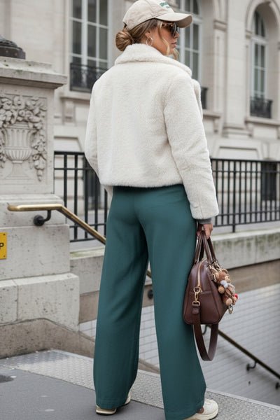 Pantalón fluido de fit wide leg, cintura alta con pretina, trabillas, pinzas frontales y bolsillos delanteros. Cierre frontal con cremallera oculta y detalle de botón lateral en pretina.