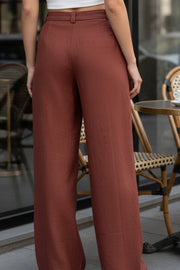 Pantalón fluido de fit wide leg, cintura alta con pretina, trabillas, pinzas frontales y bolsillos delanteros. Cierre frontal con cremallera oculta y detalle de botón lateral en pretina.