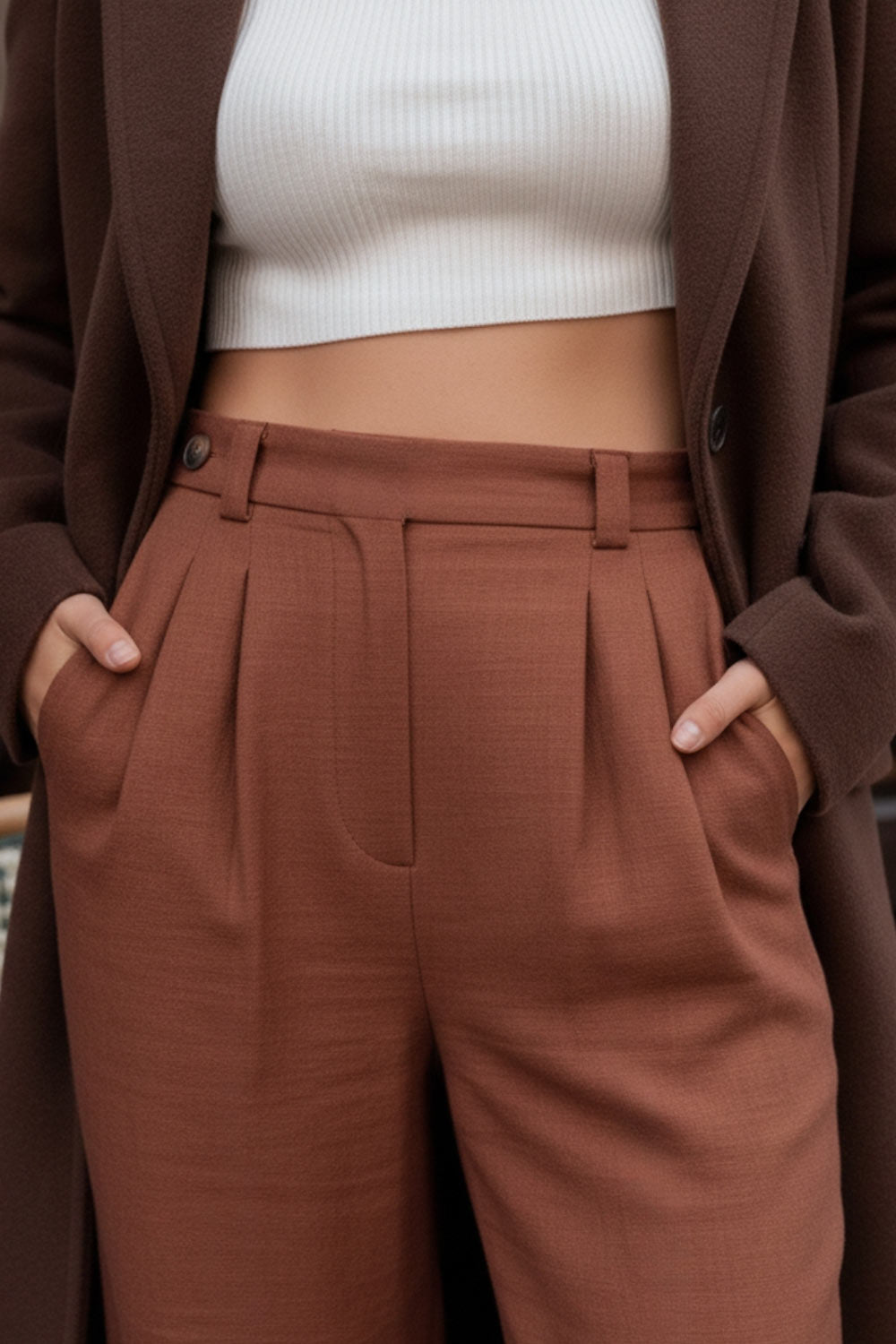 Pantalón fluido de fit wide leg, cintura alta con pretina, trabillas, pinzas frontales y bolsillos delanteros. Cierre frontal con cremallera oculta y detalle de botón lateral en pretina.