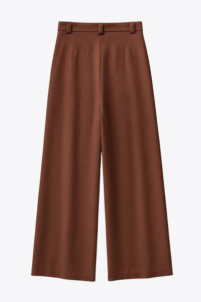 Pantalón fluido de fit wide leg, cintura alta con pretina, trabillas, pinzas frontales y bolsillos delanteros. Cierre frontal con cremallera oculta y detalle de botón lateral en pretina.