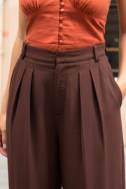 Pantalón de fit wide leg, cintura alta con pretina y trabillas, pinzas frontales, bolsillos delanteros, cierre frontal con broche y cremallera ocultos.