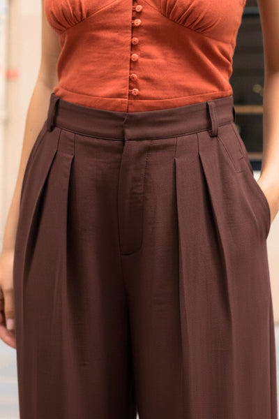 Pantalón de fit wide leg, cintura alta con pretina y trabillas, pinzas frontales, bolsillos delanteros, cierre frontal con broche y cremallera ocultos.