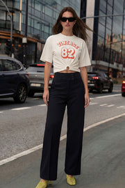 Pantalón de fit recto, cintura media con pretina ancha y trabillas, bolsillos delanteros y vivos decorativos posteriores. Cierre frontal con botones y cremallera oculta.