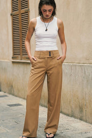 Pantalón de fit recto, cintura media con pretina ancha y trabillas, bolsillos delanteros y vivos decorativos posteriores. Cierre frontal con botones y cremallera oculta.