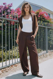Pantalón de fit balloon, estampado rayas, pinzas frontales, cintura alta con pretina cruzada y trabillas, bolsillos delanteros, vivo decorativo posterior, cierre frontal con botón y cremallera oculta.