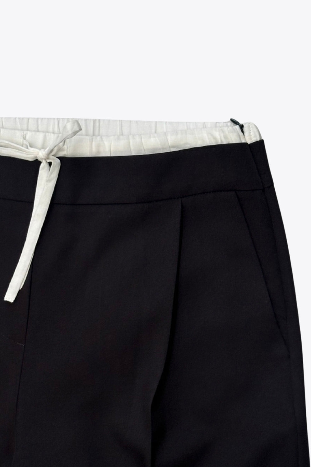 Pantalón de fit recto, pinzas frontales, cintura alta con pretina, detalle interior tipo boxer en contraste, jareta frontal ajustable, bolsillos frontales, vivo decorativo posterior y cierre lateral con cremallera oculta.