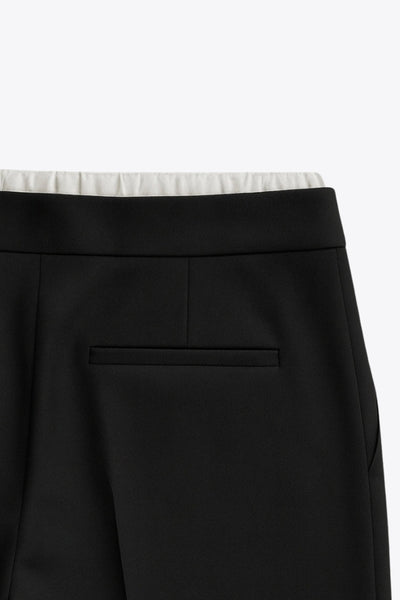 Pantalón de fit recto, pinzas frontales, cintura alta con pretina, detalle interior tipo boxer en contraste, jareta frontal ajustable, bolsillos frontales, vivo decorativo posterior y cierre lateral con cremallera oculta.