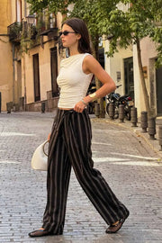Pantalón de estampado rayas, fit wide leg, cintura alta y cruce frontal con lazo amarrable lateral. Detalle decorativo en pretina frontal.