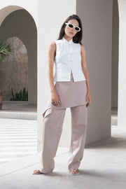 Pantalón recto de cintura alta con pretina, detalle de sobrefalda cruzada decorativa con bajo asimétrico, trabilla lateral, vivo decorativo posterior, cierre frontal con broche y cremallera ocultos.