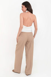 Pantalón de fit recto, cintura media con pretina y trabillas, pinzas frontales con raya, bolsillos delanteros y vivos decorativos posteriores. Cierre frontal con broche y cremallera ocultos.